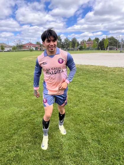 Christian Tavarez, extremo derecho de La Calle Maldita, con el uniforme salmón del equipo en una cancha de pasto