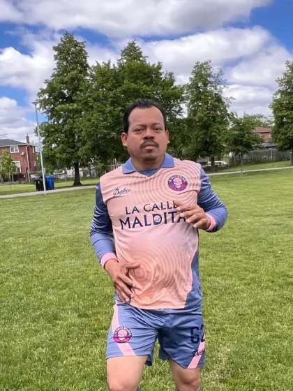 Orlando Izquierdo, defensa central de La Calle Maldita, con el uniforme salmón del equipo en una cancha de pasto